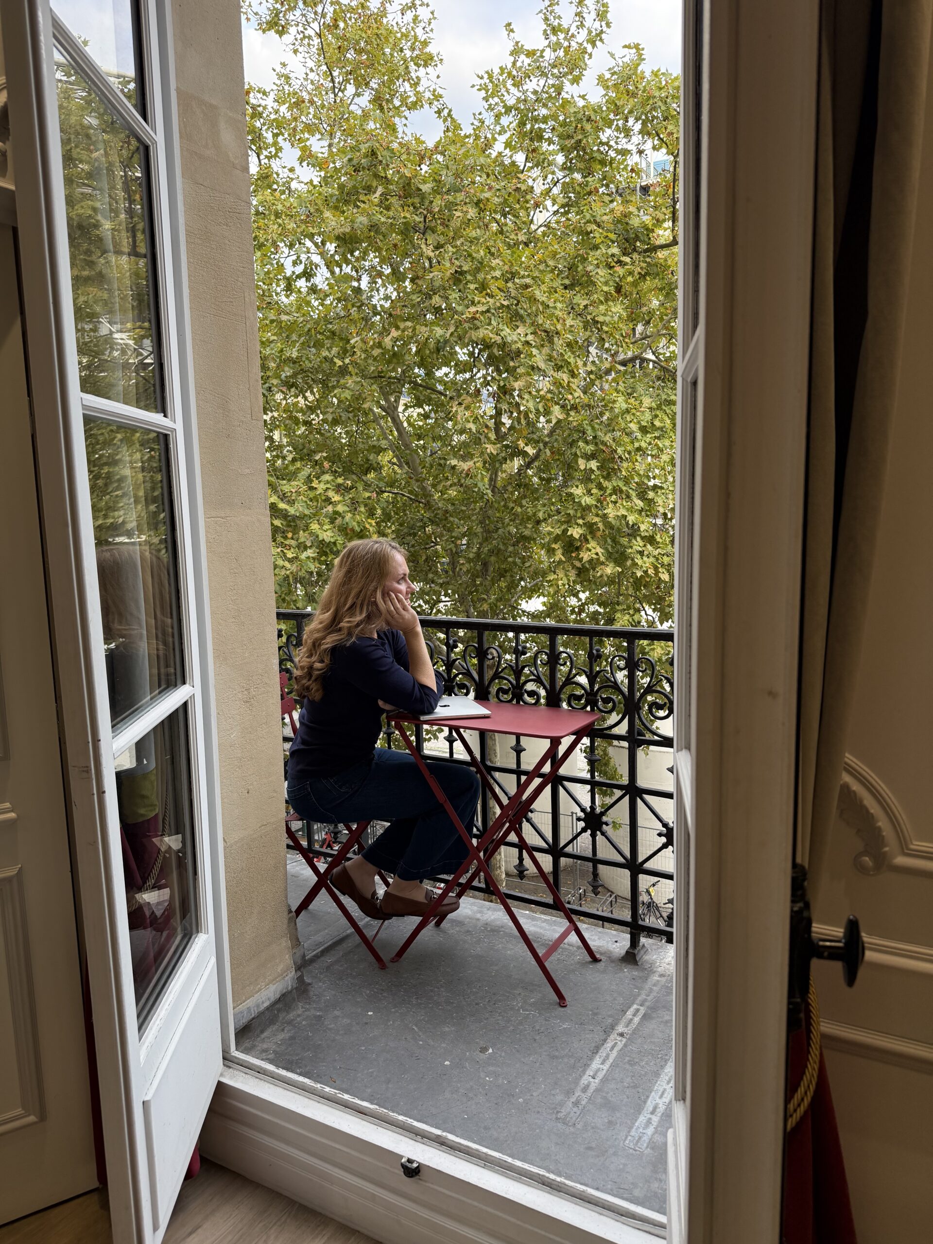 jessica on balcony with laptop in Paris reflecting on tips for small business owners